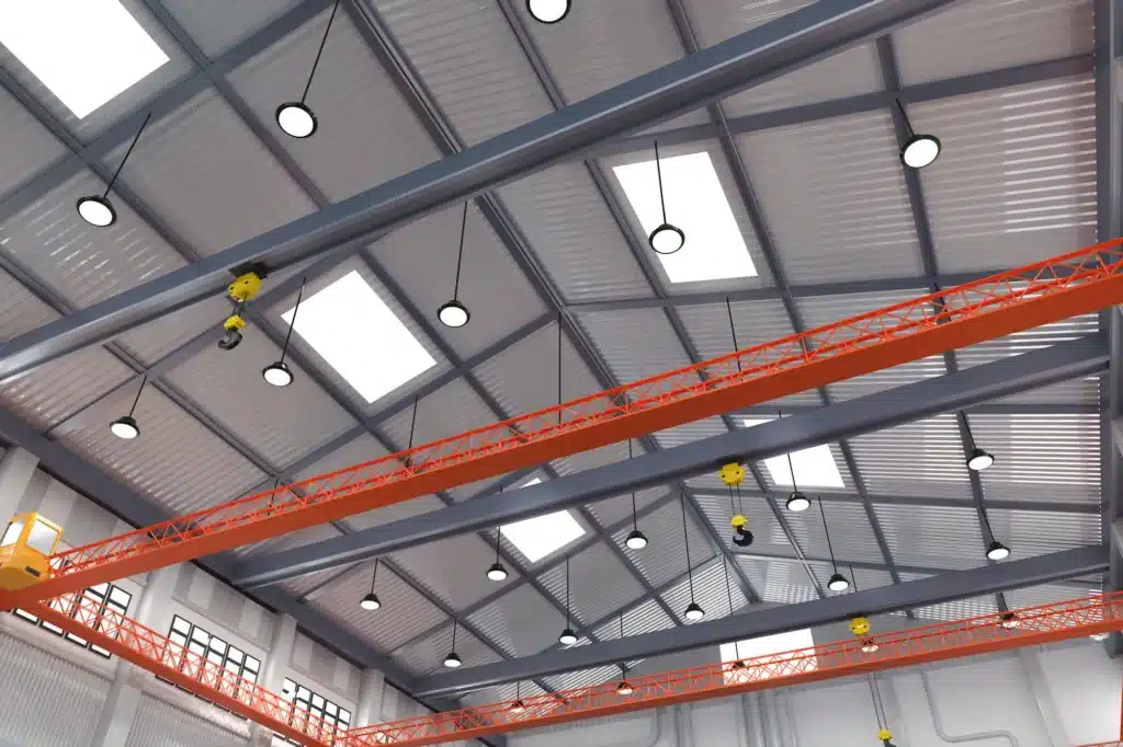 Round ceiling lights beneath steel roof beams in an industrial hall